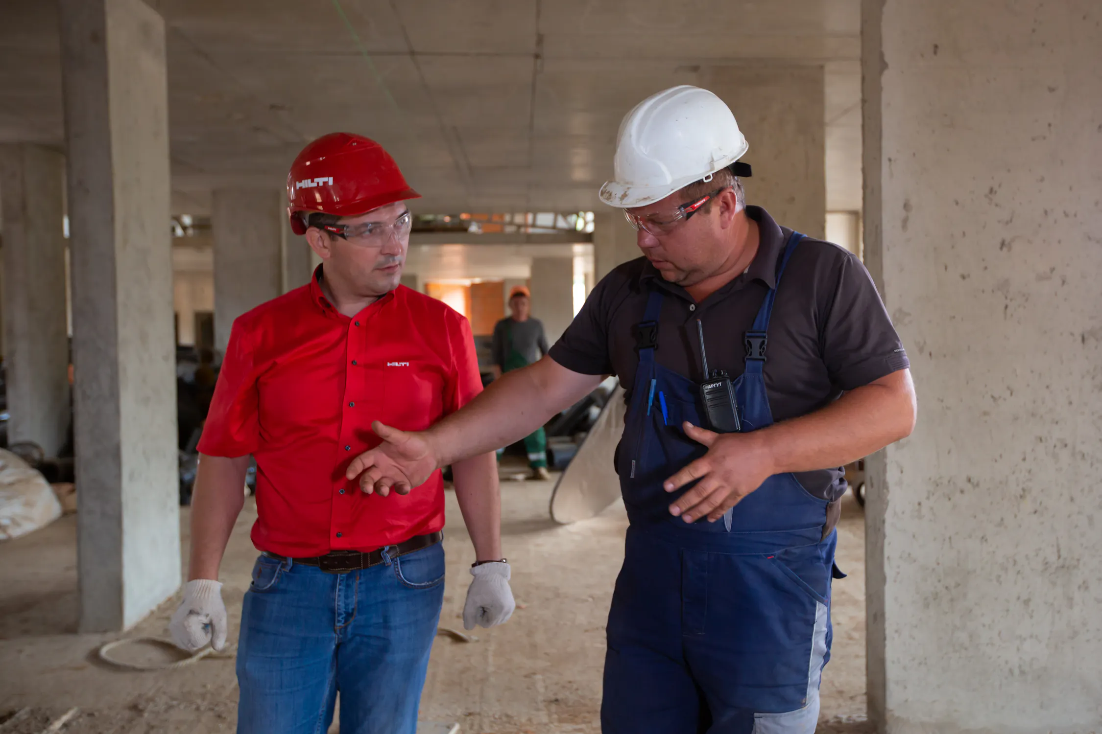 Construction workers reviewing plans on a building site at sunset